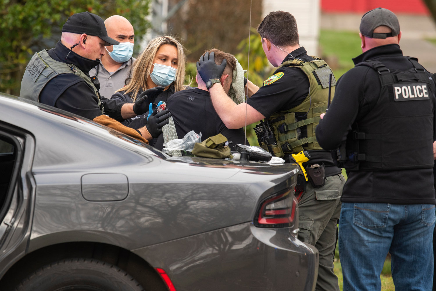 Centralia K9 Officer Stephen Summers is treated for injuries and helped into the back of an ambulance in the 100 block of Southwest Alfred Street in Chehalis after responding to a call.
